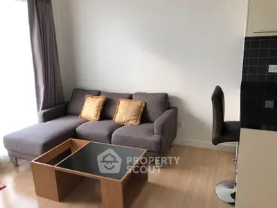 Modern living room with stylish gray sofa and wooden coffee table in bright apartment.