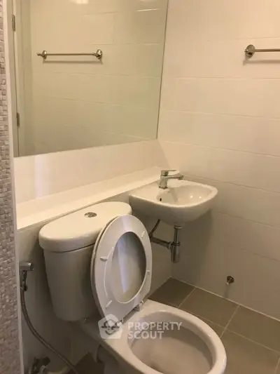Compact bathroom with modern fixtures and neutral tiles, ideal for efficient space utilization.