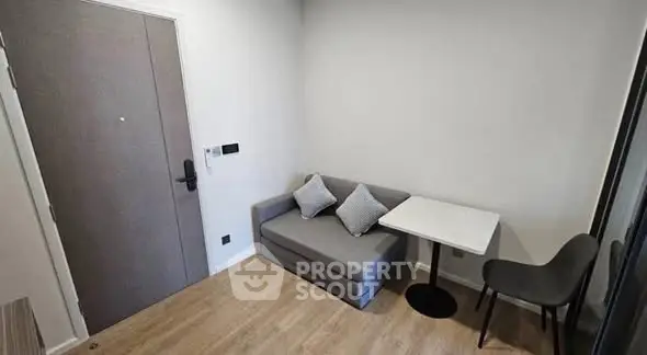 Cozy small living area with modern sofa and dining table, perfect for compact urban living.