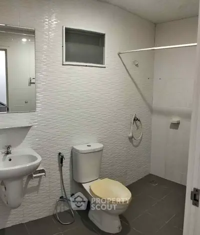 Modern bathroom with sleek white tiles and contemporary fixtures.