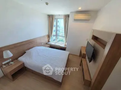 Modern bedroom with wooden furniture and city view window, featuring a cozy bed and mounted TV.