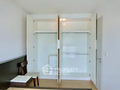 Spacious bedroom with open closets and modern furniture