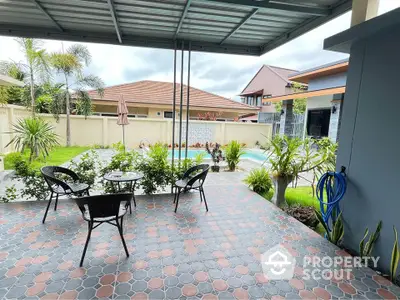 Charming patio with pool view in a modern home, perfect for relaxation and outdoor dining.