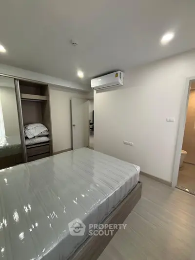 Modern bedroom with sleek design and air conditioning in a stylish apartment.