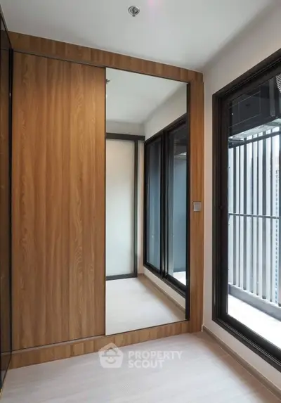 Modern apartment with large mirrored wardrobe and floor-to-ceiling windows