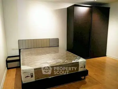 Spacious bedroom with modern design and ample storage in a stylish apartment.