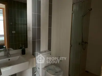 Modern bathroom with sleek design featuring a glass shower and contemporary fixtures.