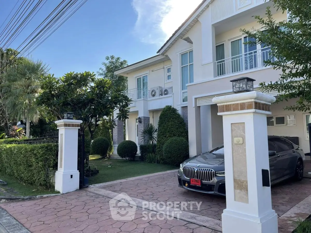 Elegant two-story house with manicured garden and luxury car in driveway