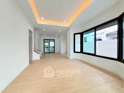 Spacious modern living room with large windows and elegant lighting