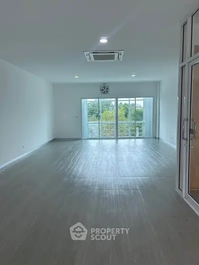 Spacious modern living room with large windows and balcony view, perfect for natural light lovers.