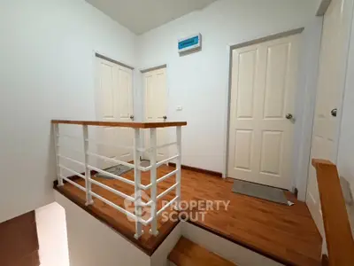 Spacious hallway with wooden flooring and modern railing in a contemporary home.