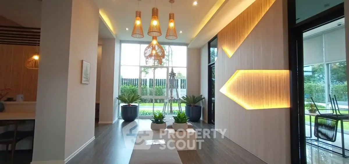 Modern lobby with stylish lighting and large windows overlooking greenery.