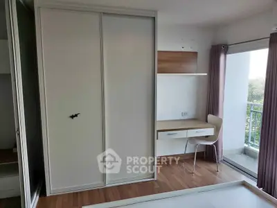 Modern bedroom with built-in wardrobe and study desk, featuring a balcony view.