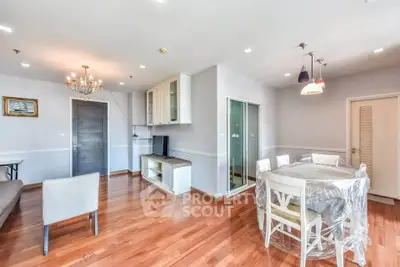 Spacious living room with elegant wooden flooring and modern lighting fixtures.