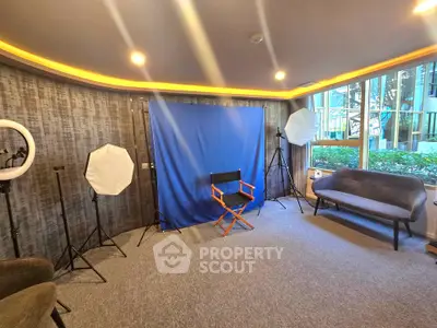 Spacious room with professional photography setup and large windows.