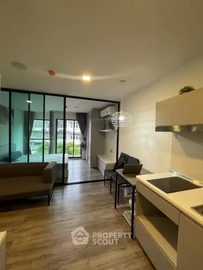 Modern open-plan living room with kitchen and large windows offering a great view