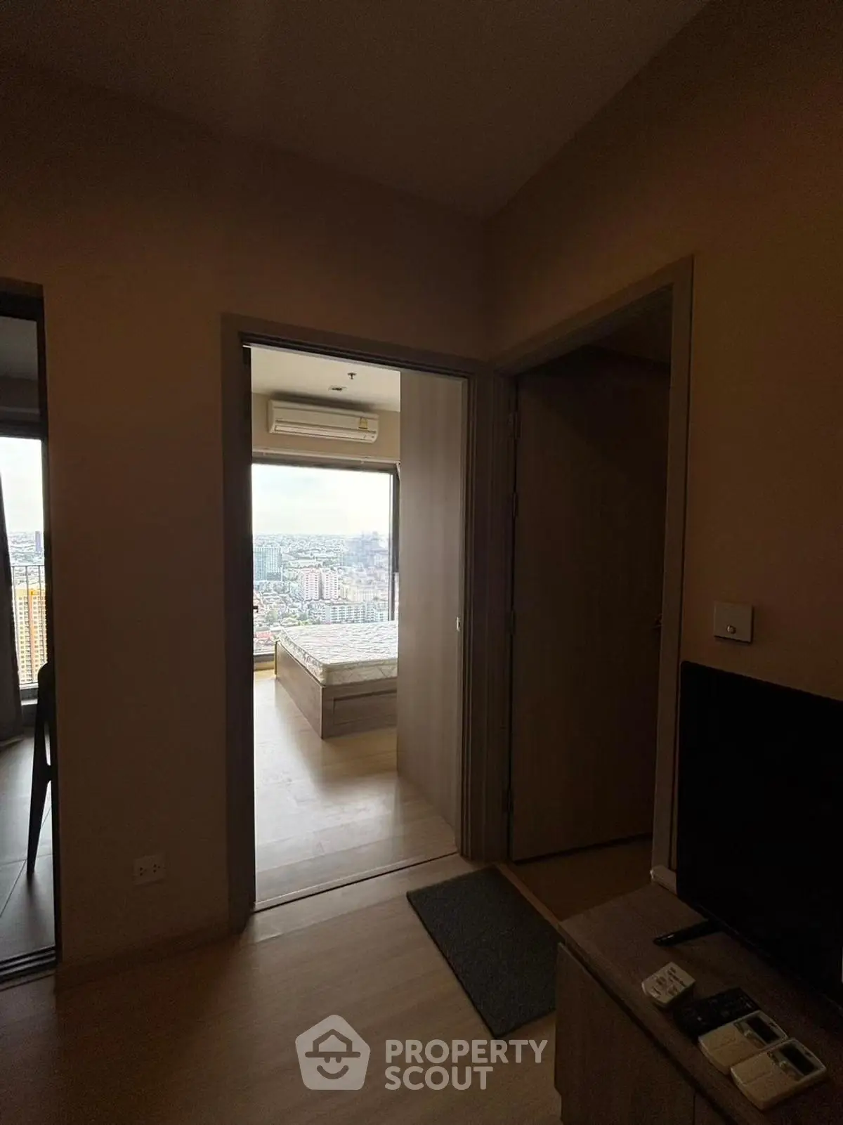 Cozy apartment interior with a view of the city skyline from the bedroom.