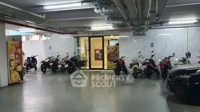 Modern parking area with motorcycles and sleek design in urban building.