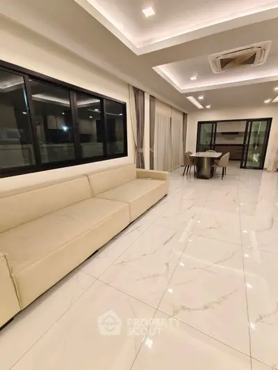 Luxurious modern living room with elegant marble flooring and spacious open layout.