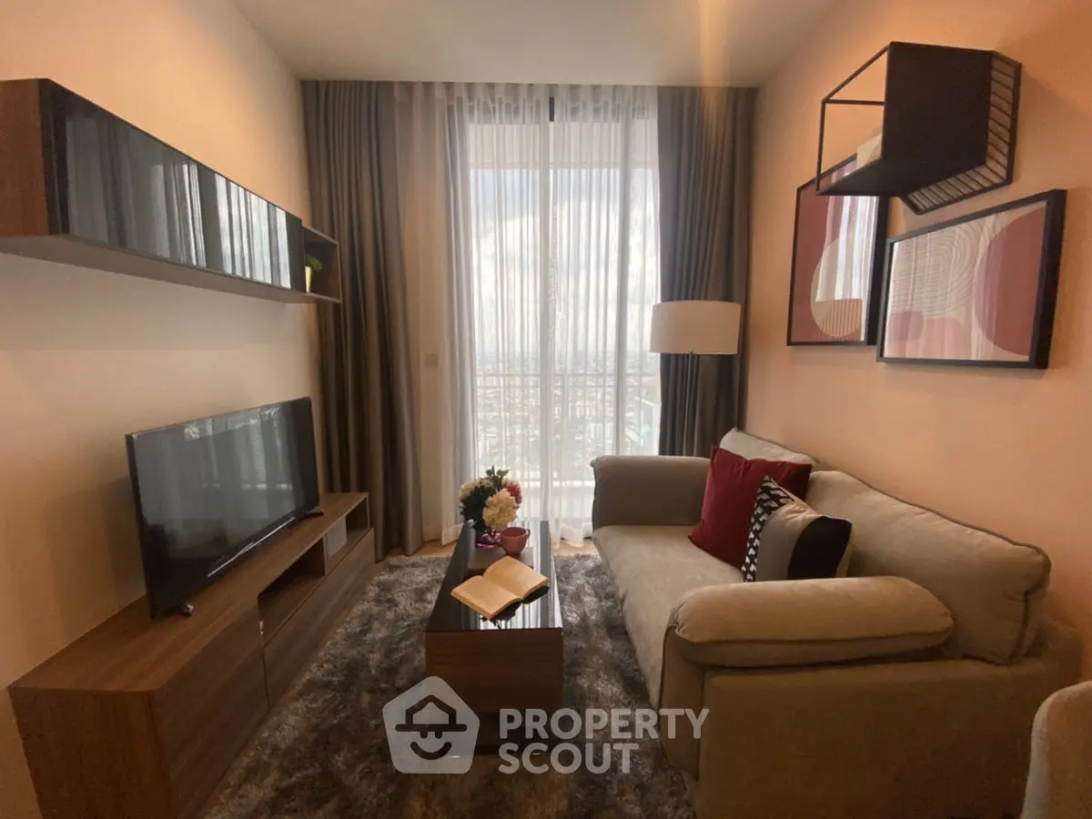 Cozy living room with modern decor, featuring a plush sofa, stylish shelving, and a large window with natural light.