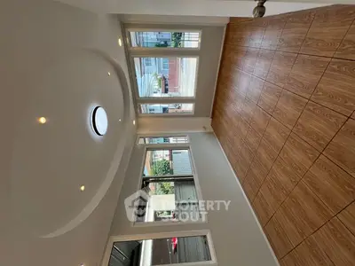 Spacious room with large windows and wooden flooring, perfect for natural light lovers.