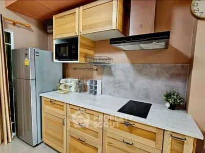 Modern kitchen with wooden cabinets, sleek appliances, and elegant countertop in a cozy home setting.