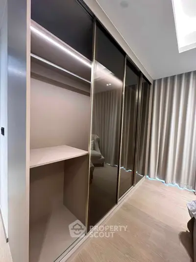 Spacious modern closet with sliding glass doors in a stylish bedroom setting.