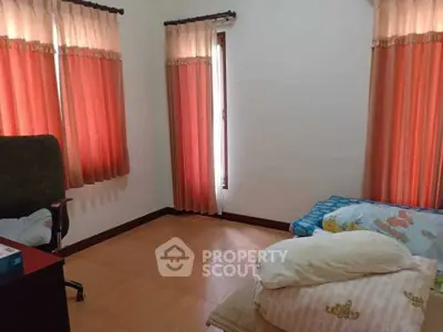 Cozy bedroom with natural light and simple furnishings, ideal for relaxation.