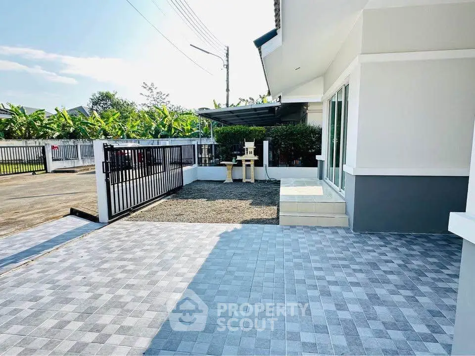 Spacious modern home exterior with gated driveway and tiled patio