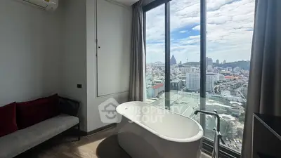 Luxurious bathroom with freestanding bathtub and stunning city view from floor-to-ceiling windows.