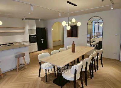 Modern dining area with stylish lighting and wooden flooring in open-plan layout.