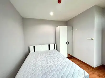 Modern minimalist bedroom with sleek white wardrobe and cozy bed in a bright apartment.