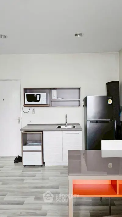 Modern kitchen with sleek appliances and open layout in a stylish apartment.