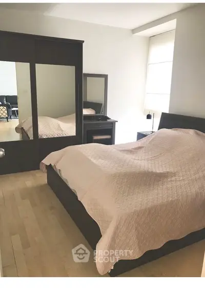 Spacious bedroom with elegant wooden furniture and natural light