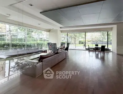 Spacious modern living room with floor-to-ceiling windows and garden view