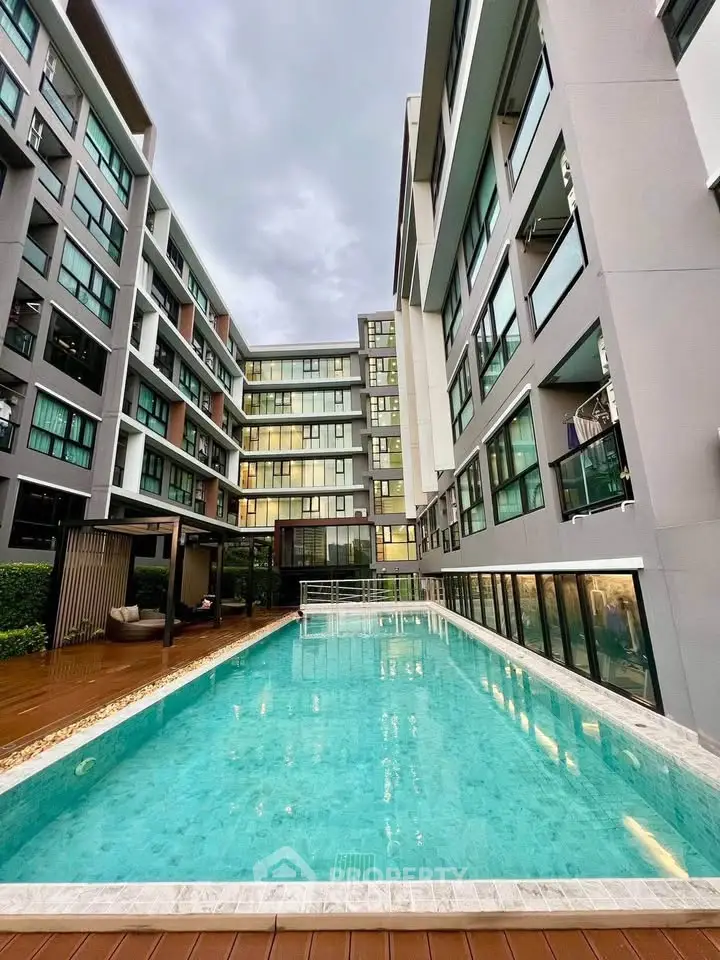 Modern apartment complex with a pristine swimming pool and stylish architecture.