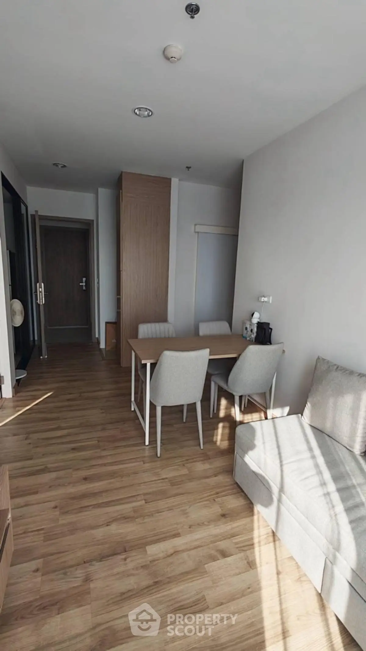 Modern living room with wooden flooring and cozy furniture in a bright apartment.