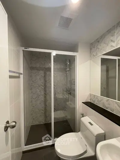 Modern bathroom with glass shower enclosure and sleek design.