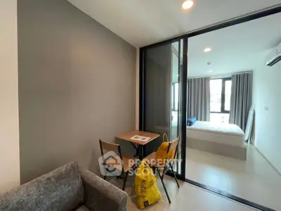 Modern apartment interior with cozy living area and glass partitioned bedroom