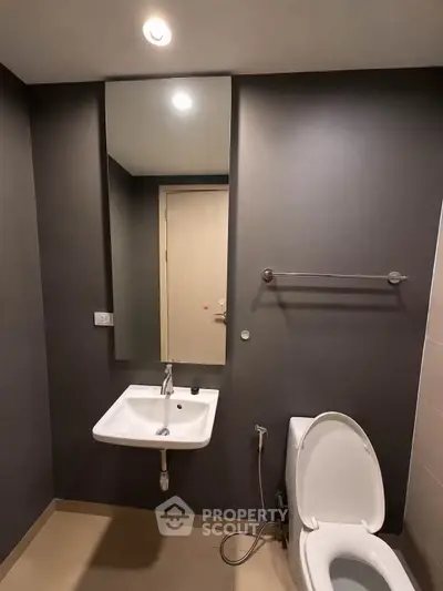 Modern bathroom with sleek design featuring a wall-mounted sink and toilet.