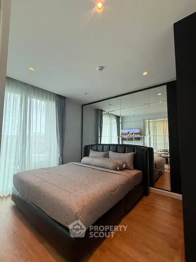 Modern bedroom with stylish decor and large windows offering natural light