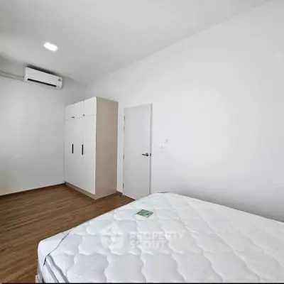 Spacious bedroom with modern wardrobe and air conditioning, perfect for comfortable living.