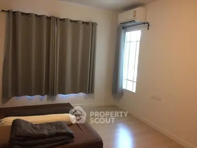 Cozy bedroom with air conditioning and natural light, perfect for relaxation.