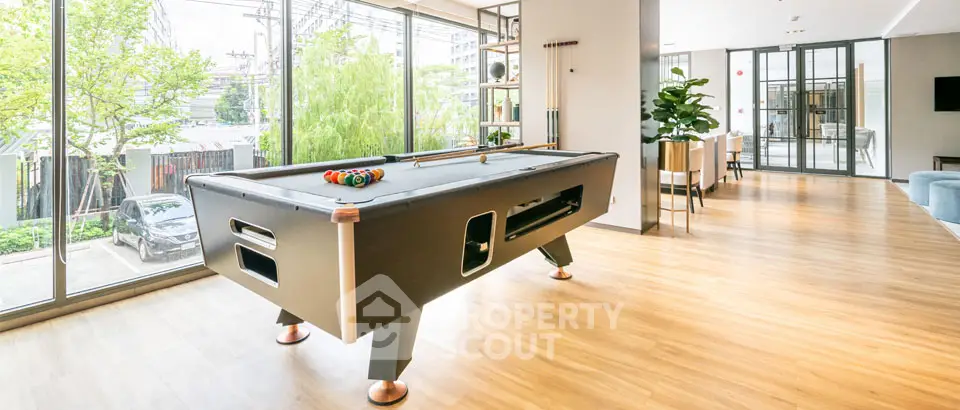 Spacious modern living area with pool table and large windows