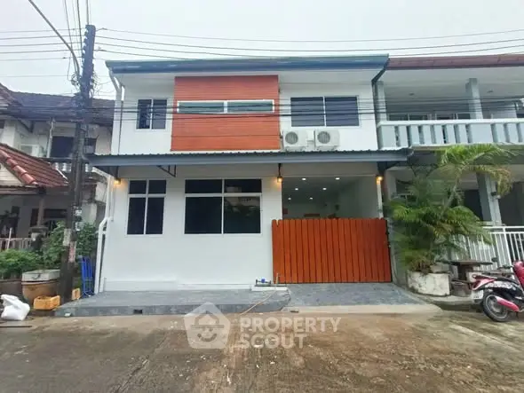 Charming two-story house with modern facade and driveway in suburban neighborhood.