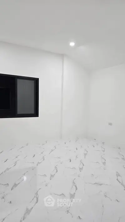 Minimalist white room with marble flooring and a window, perfect for modern living.