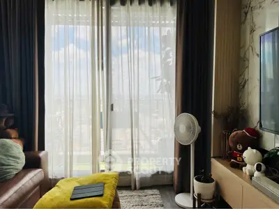 Cozy living room with balcony view, featuring modern decor and natural light.