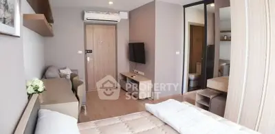 Modern bedroom with neutral tones, featuring a cozy bed, wall-mounted TV, and air conditioning.