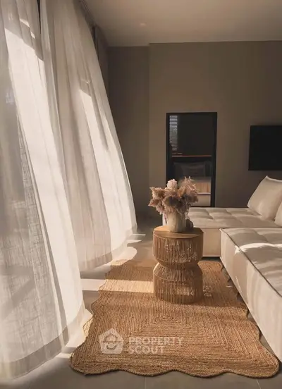 Elegant living room with natural light, cozy beige sofa, and stylish decor for a serene ambiance.