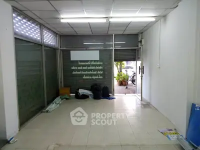 Spacious empty commercial space with tiled flooring and glass entrance, ideal for new business setup.